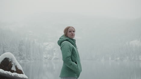 woman enjoying a snowy landscape by a lake