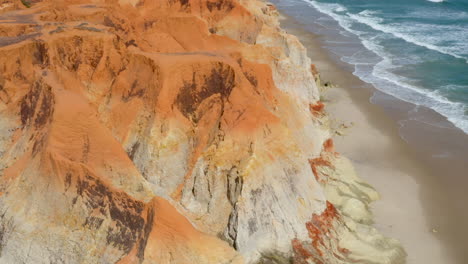 Vista-Aérea-Del-Mar,-Olas,-Acantilados-Y-Pequeño-Pueblo,-Morro-Branco,-Ceará,-Brasil