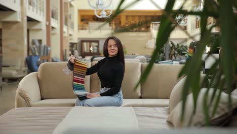 woman choosing fabric samples in furniture store