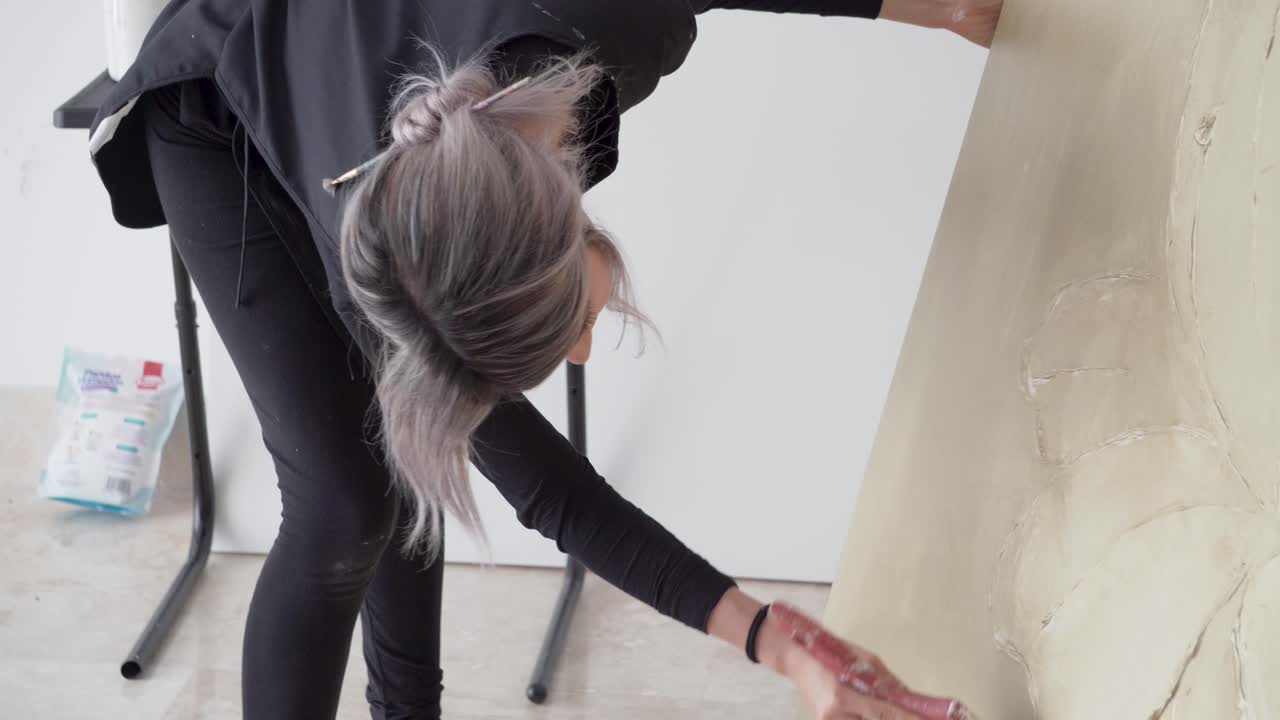 스튜디오의 대형 페인트 캔버스에서 작업하는 창의적인 아티스트