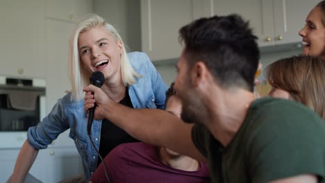 young adult friends singing at home karaoke.