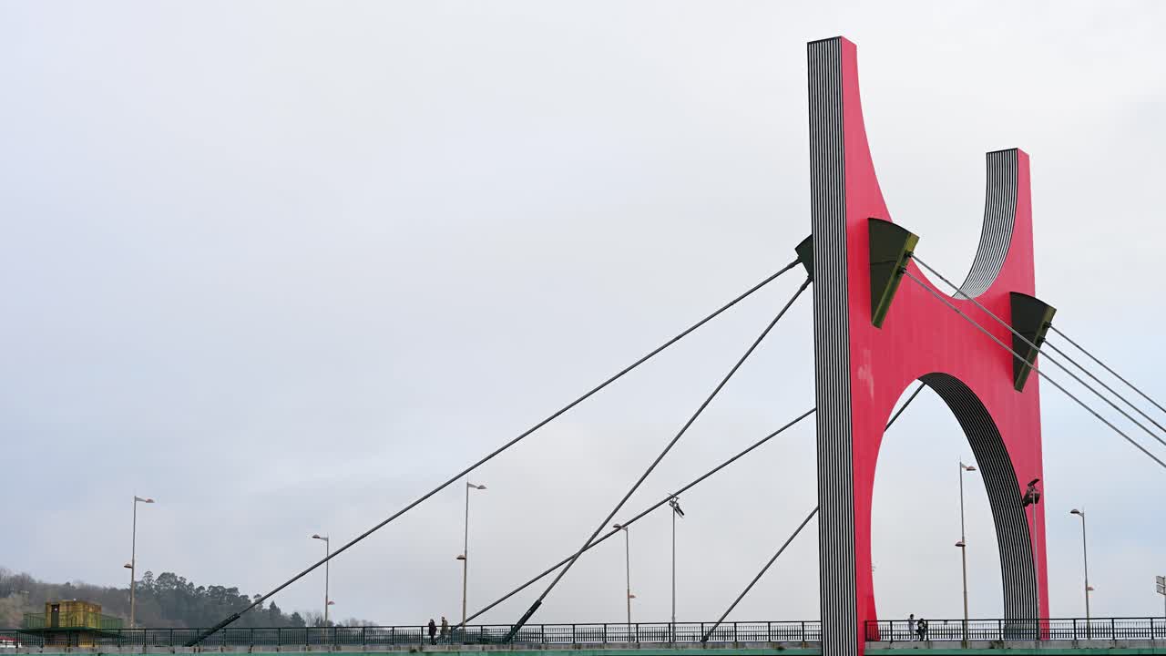 View of the La Salve Bridge, a red bridge that merges with the Guggenheim Bilbao Museum, featuring 23.5 meters of clearance for boat passage in Bilbao, Spain.