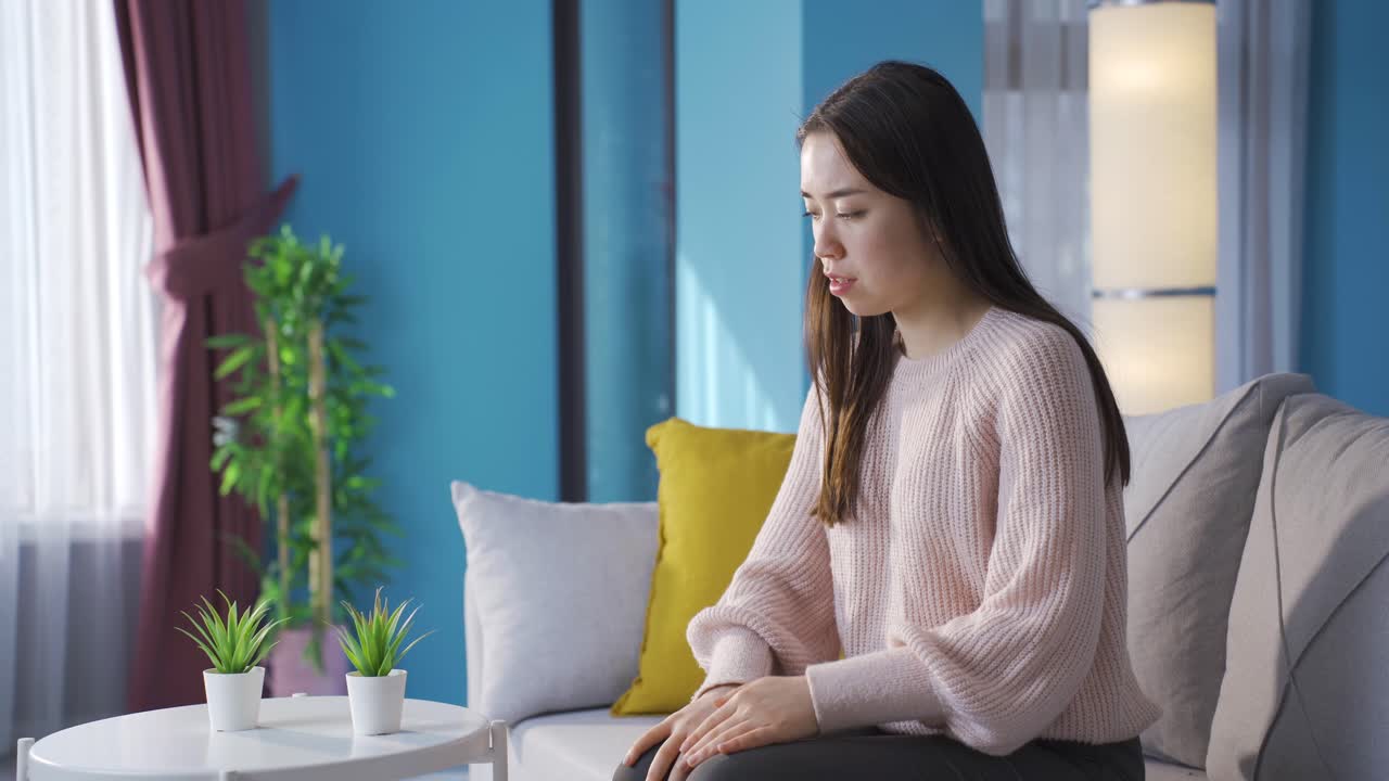 슬픈 피곤한 젊은 아시아 여성이 이마를 만지고, 우울하고, 화가 나고,