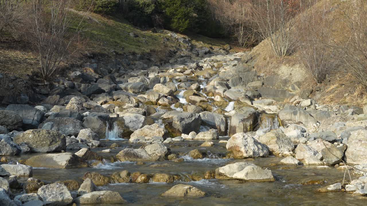 rocky mountain stream with clear water flowing through an alpine valley
