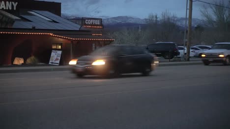 Roadside-diner-selling-coffee,-beer-and-pizza-as-cars-drive-by-at-nighttime