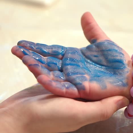 Child hand painted in colorful paint. Early childhood education. Little painter.