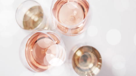 composite of glasses of white, rose and red wine over white background