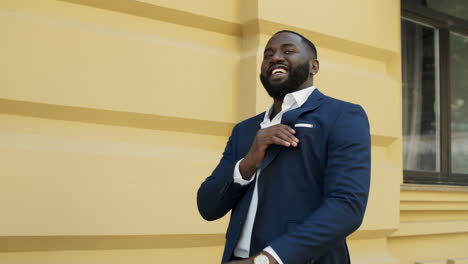 Smiling-business-man-walking-in-slow-motion.-Afro-businessman-at-urban-street.