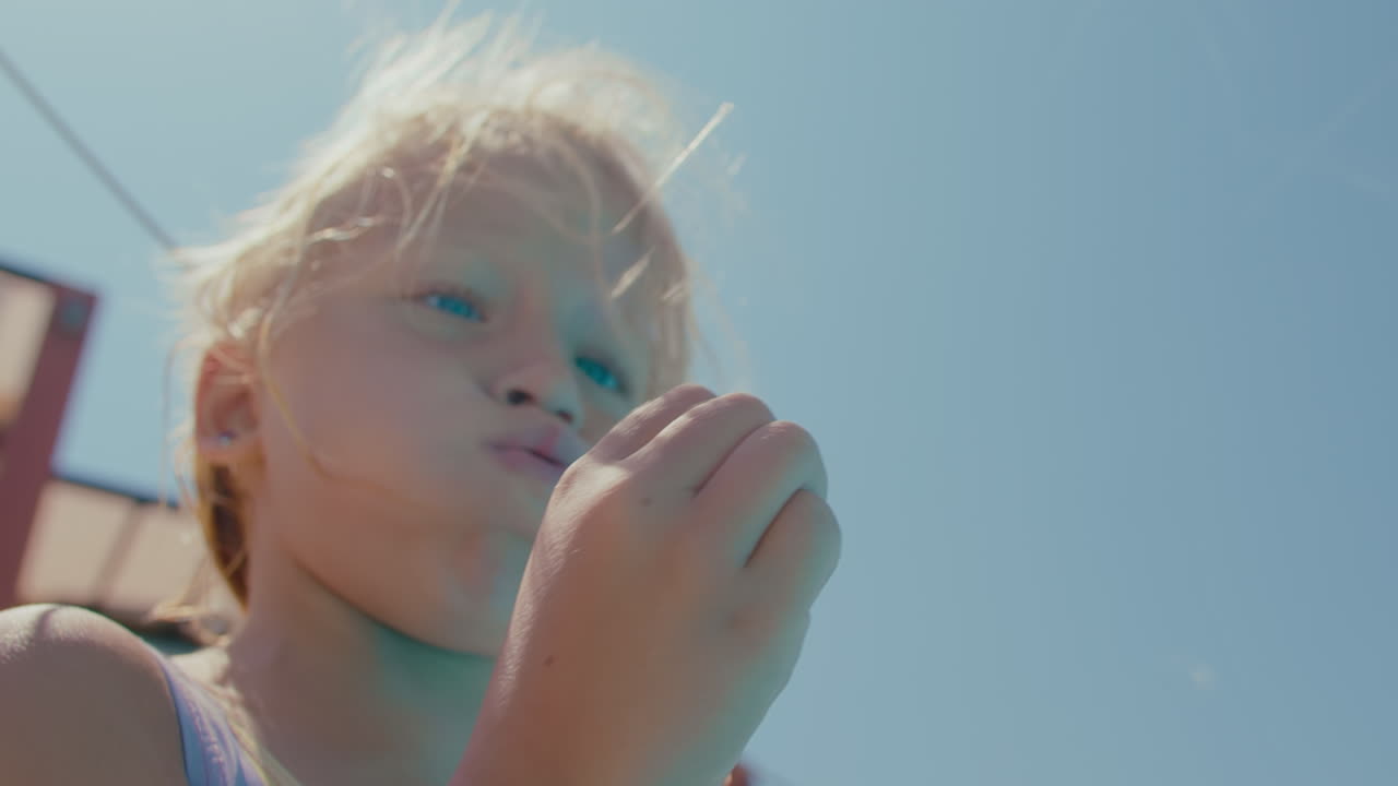 느린 속도로 사탕수수 씨을 불어넣는 소녀