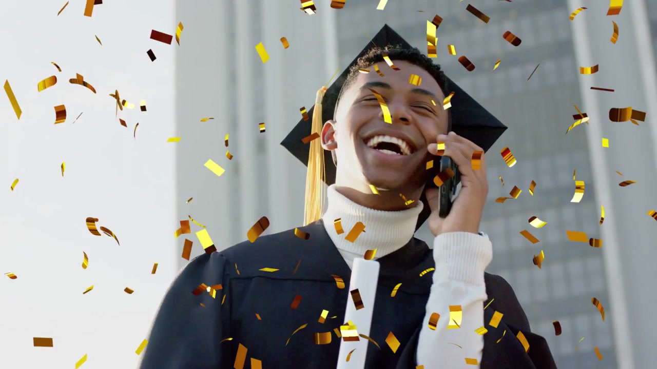 Male grad speaking on cell celebrating graduation with diploma, causing gold confetti around him