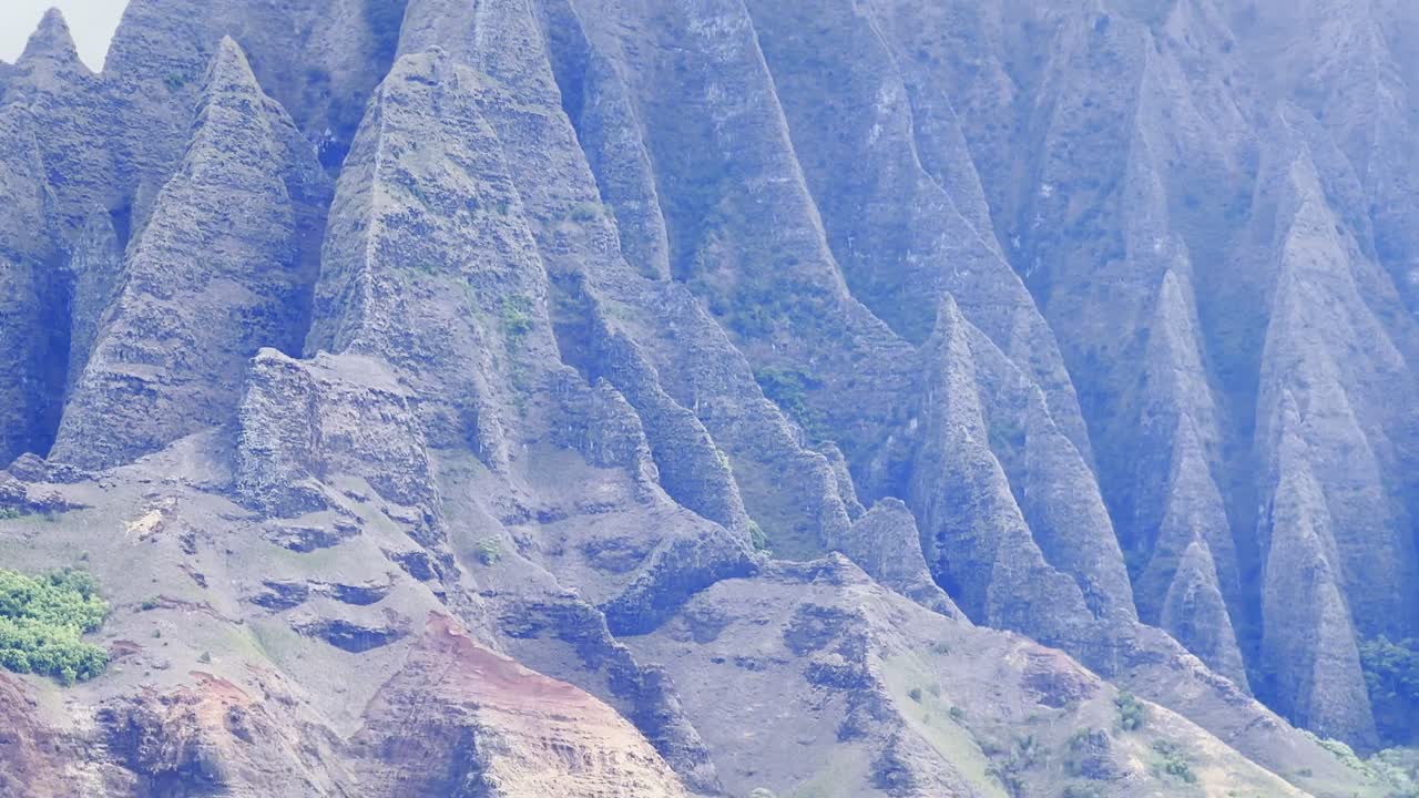 Cinematic long lens booming down shot from a boat of the iconic ridges of the Na Pali Coast in Kaua'i, Hawai'i