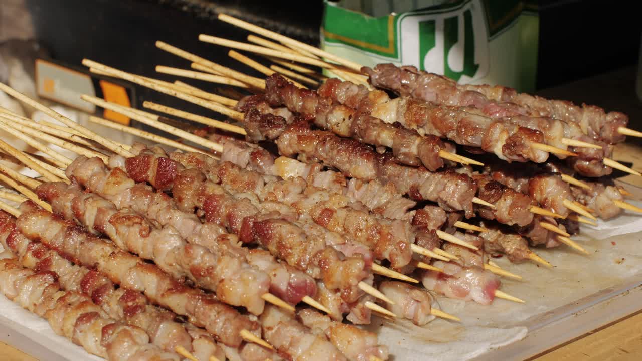 Pork meat skewer on fire, Mutton barbecue close-up. Fried meat for kebab. Cooking grilled meat beef chicken lamb BBQ . Kebab on grill. Chinese street local market with traditional food. Asian fast food.
