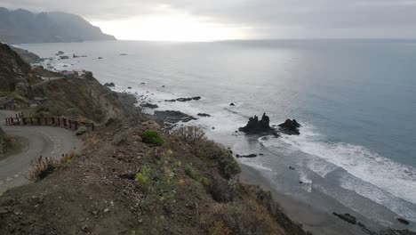 Vista-Aérea-De-Una-Playa-De-Arena-Negra-Bajo-Los-Acantilados