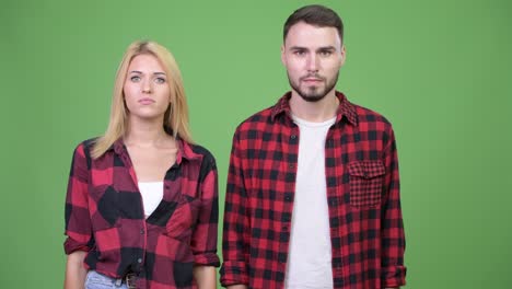 young couple with finger on lips together