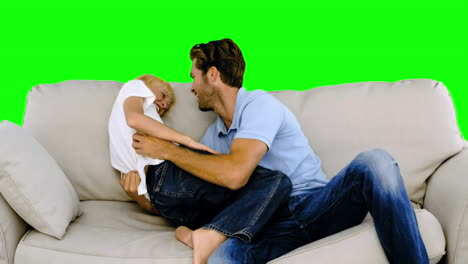 Padre-Haciéndole-Cosquillas-A-Su-Hijo-En-El-Sofá-En-Pantalla-Verde