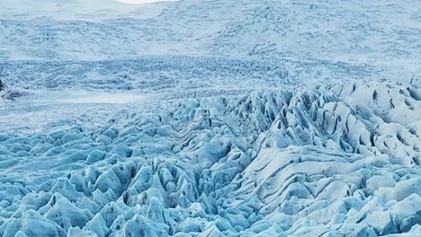 aerial landscape view of textured ice formations of a glacier in iceland, at dusk