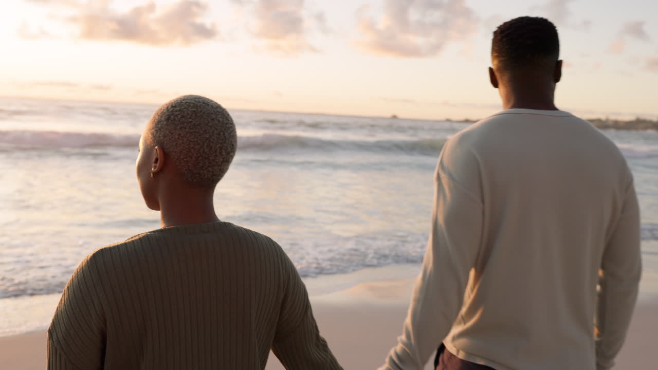 Beach, love and happy couple walking in the ocean