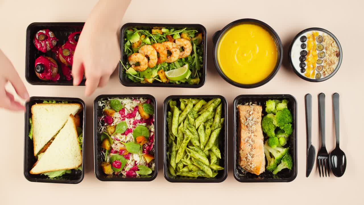 Top View of Hands Arranging Healthy Meal Prep Containers