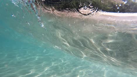 vista submarina en cámara lenta extrema de una ola rompiente en la costa tomada desde debajo de la ola