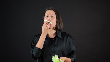 young female vegan eating cabbage leaf passionately in front of camera, slow motion