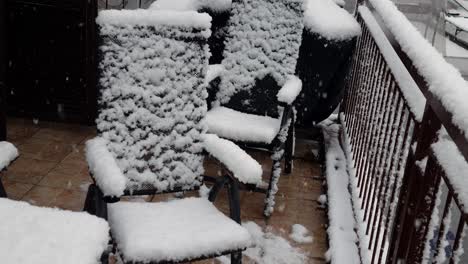 invierno en el balcón, sillas de metal cubiertas de nieve