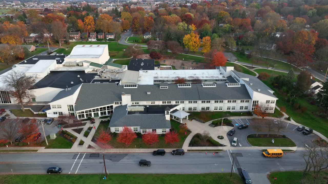 거리에 주차된 미국 고등학교 건물과 학교 버스