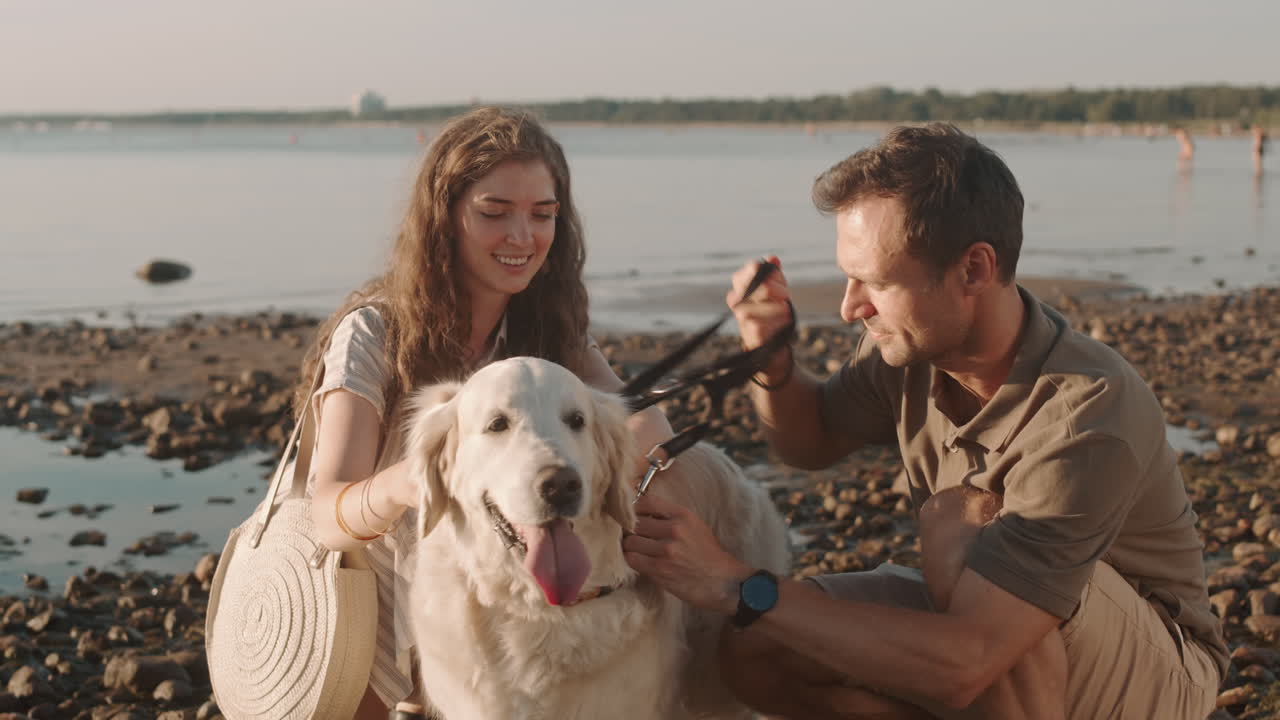 Couple Petting Dog on Seashore