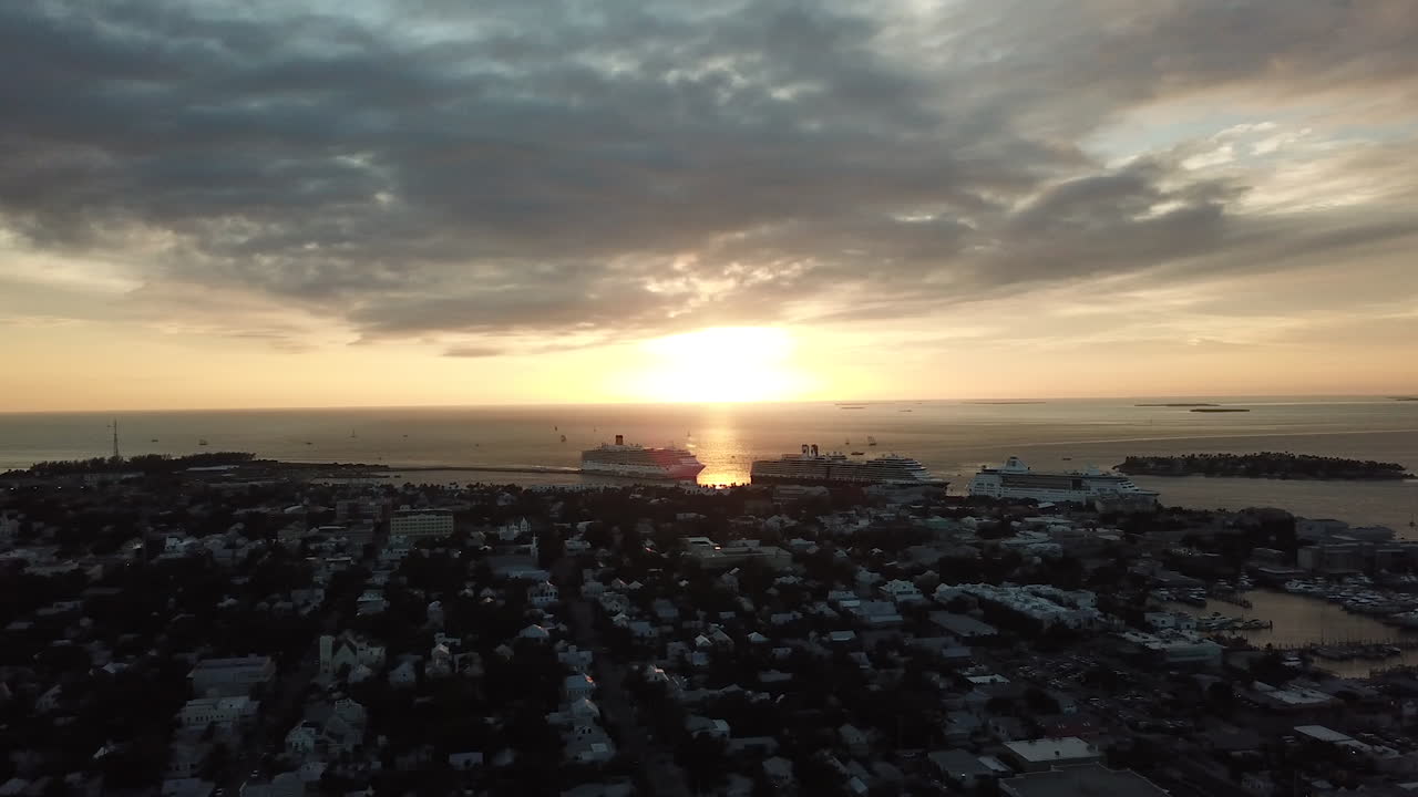 Cruise ships docked at Key West cruise ship port during golden hour sunset from vantage point of drone