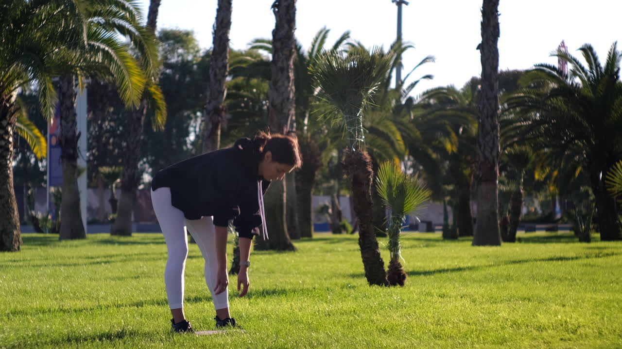 저항 밴드 와 함께 공원 에서 운동 하는 여자