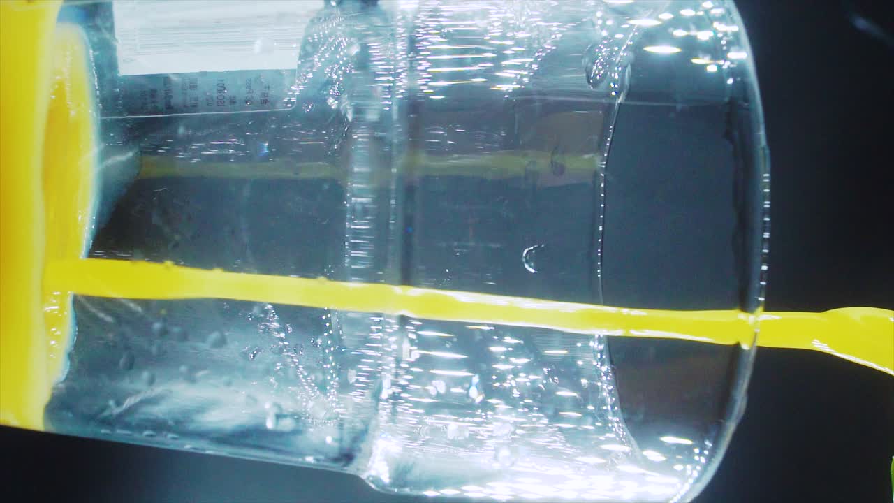 새로 압축 된 오렌지 주스 로 가득 찬 잔 의 수직 매크로 클로즈업  ⁇ , 슬로우 모션, 스튜디오 조명, 4k 비디오