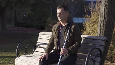 blind man's loneliness. he is sitting in the park.