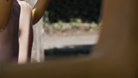 Slow-motion-close-up-of-a-child's-hands-swinging-on-rings-in-a-park