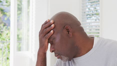 hombre mayor afroamericano cansado con dolor de cabeza