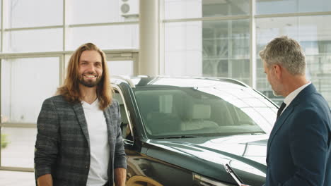 car salesman discussing a deal with a customer in a showroom