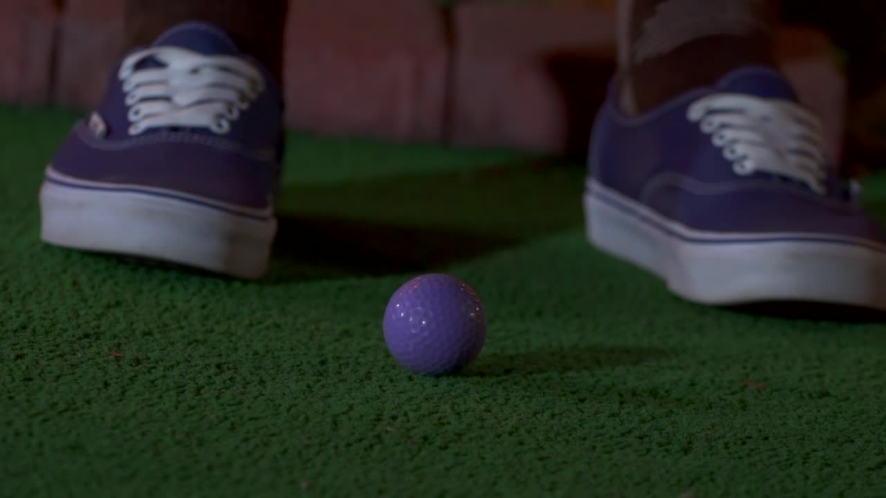 보라색 미니 골프공이 클럽에 부딪히는 클로즈업