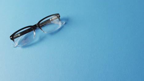 video de un par de gafas sobre un fondo azul con espacio de copia