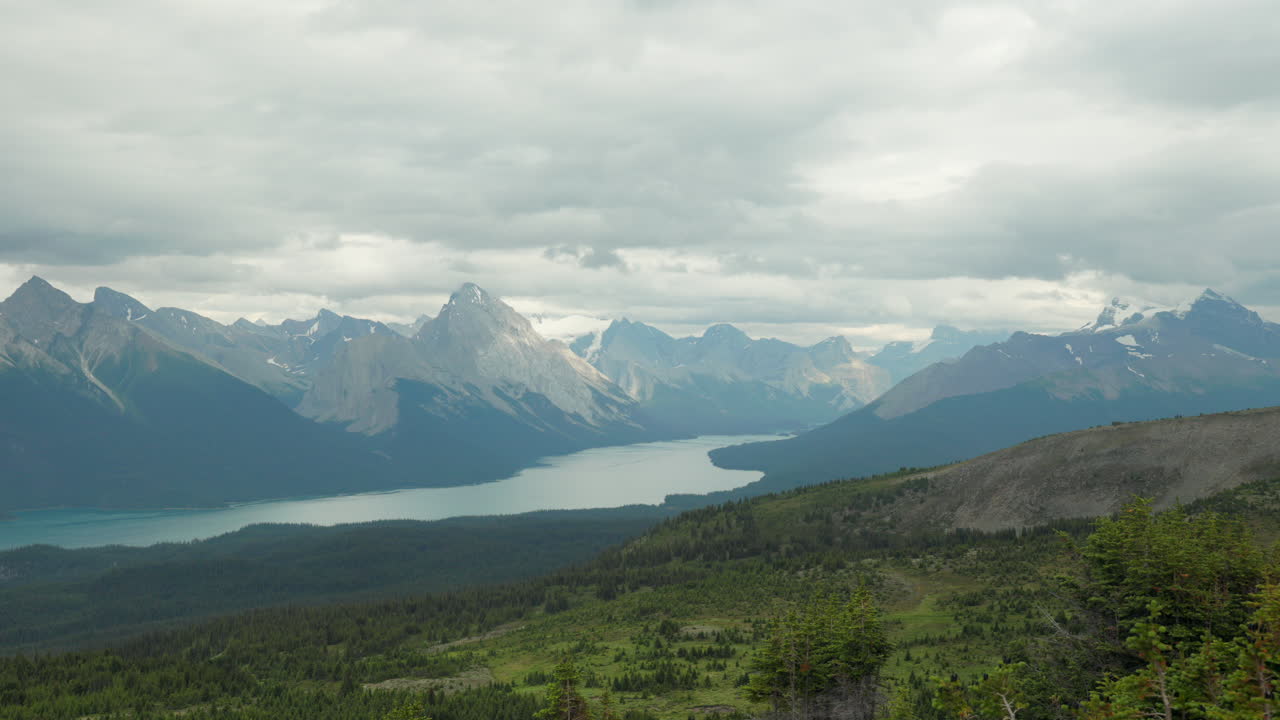 Scenic video capturing Maligne Lake and rugged mountain peaks under a dramatic cloudy sky