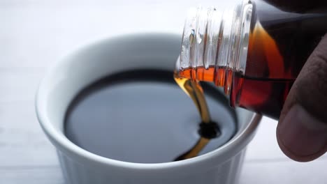 pouring dark brown sauce into a bowl