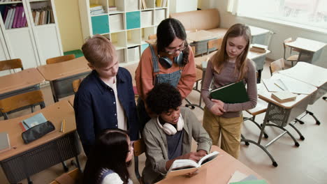 diverse group of students collaborating and reading in a classroom