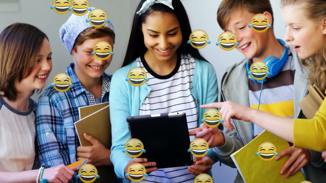 Animation of happy emoticons over smiling group of diverse students using tablet