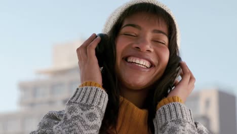 Woman-listening-to-music-on-a-winters-day