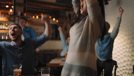 Amigos-Miran-Juntos-Emocionalmente-Viendo-Fútbol-En-La-Televisión-En-Un-Bar-Y-Celebrando-La-Victoria-De-Su-Equipo-Después-De-Marcar-Un-Gol.-Ver-Baloncesto-Hockey.-El-Disco-Anotado.-Fans-En-El-Pub