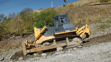 excavadora trabajando en un camino de montaña