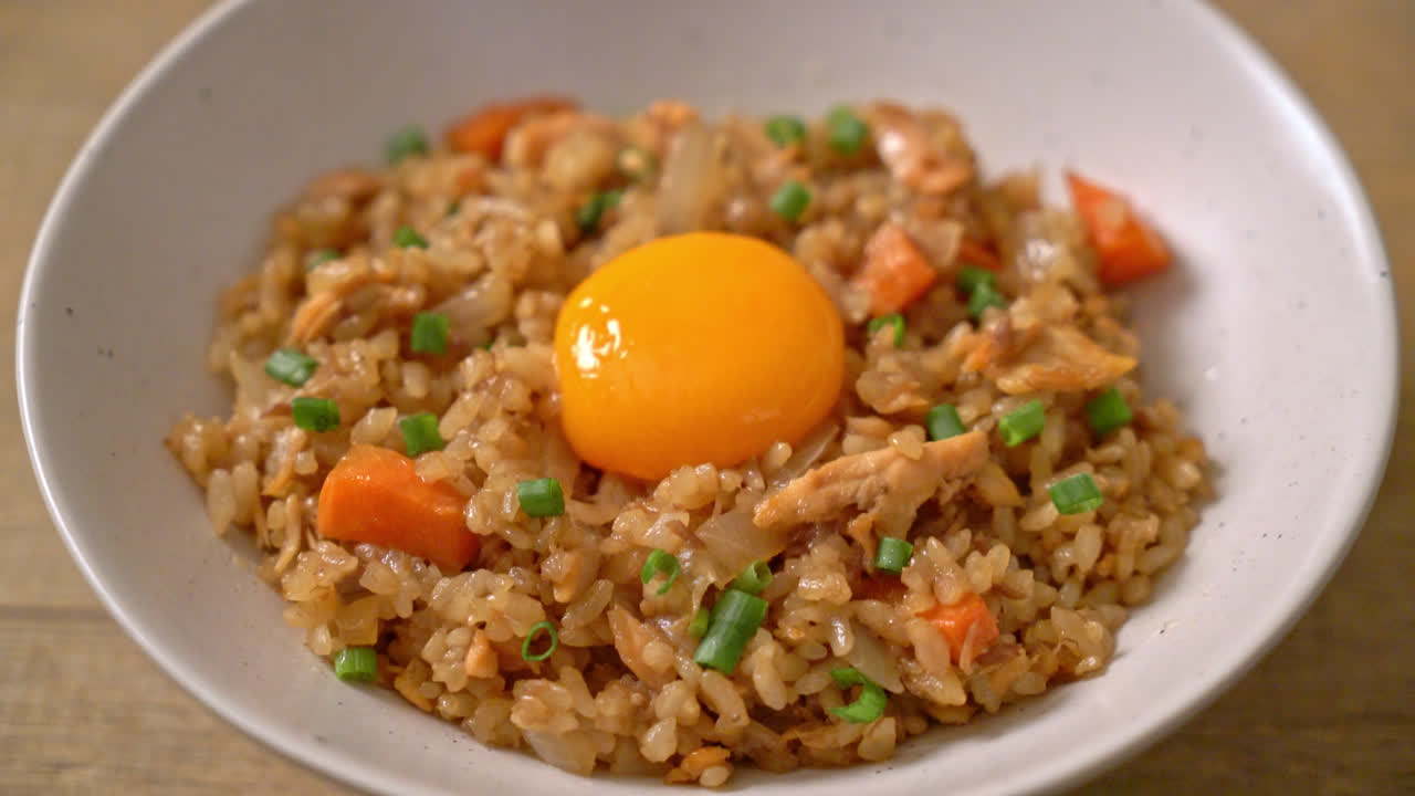 arroz frito con salmón con huevo en escabeche encima - estilo de comida asiática