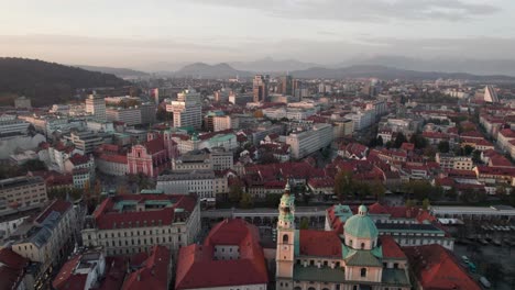 aerial forward tilt down shot in historic center ljubljana city, slovenia on a foggy day