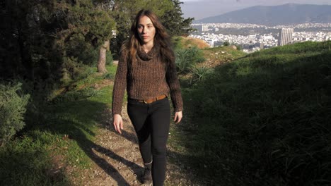young woman walks on path in lycabettus hill enjoying the view of the city of athens, greece, gimbal front tracking