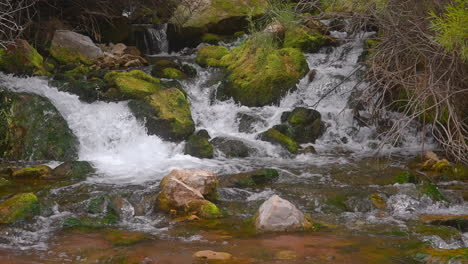 Wasserfälle-Mit-Moosigen-Felsen,-Die-Zum-Fluss-Fließen