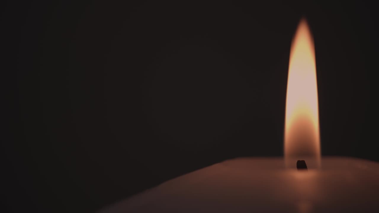 Ripresa macro di una candela che brucia al buio
