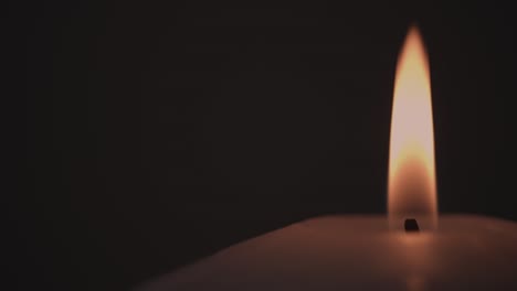 macro footage of a candle burning in the dark