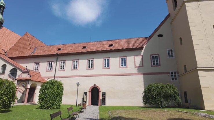 Storico convento di Český Krumlov con tetti rossi e un tranquillo cortile in una giornata di sole